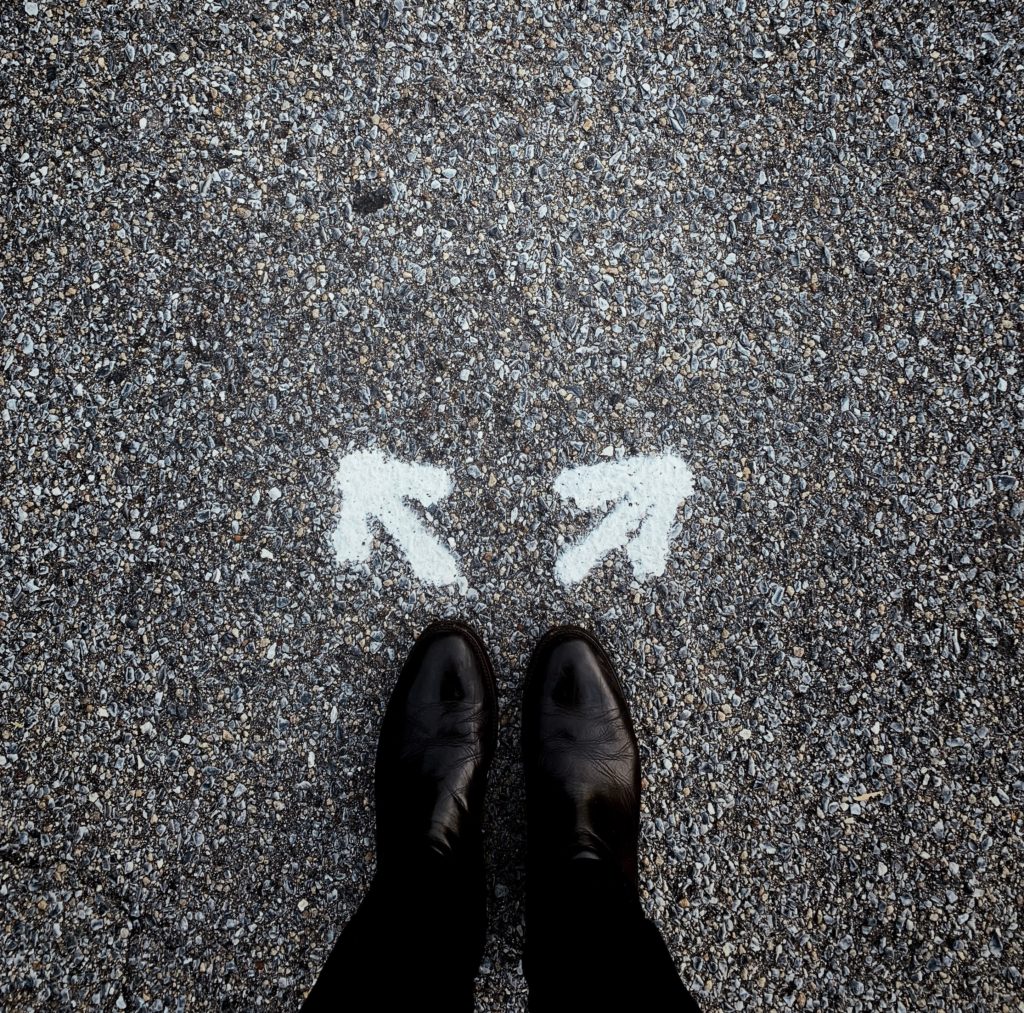 A person standing on the ground with arrows pointing in opposite directions.